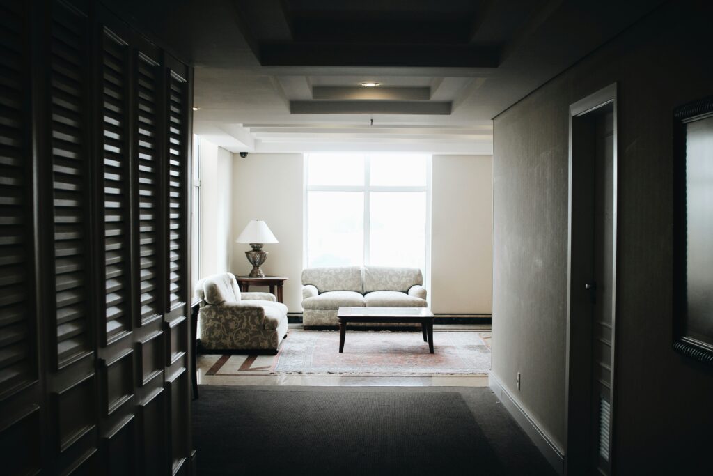 Modern hotel room with a king-size bed, neatly folded towels on the bed, a large window with city view, a coffee station, and a wall-mounted flat-screen TV — showcasing key amenities travelers look for in a hotel stay