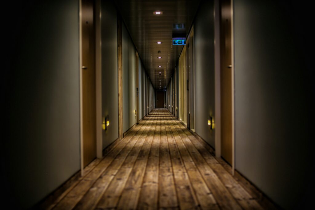Modern hotel corridor with well-lit guest room entrances and elegant interior design