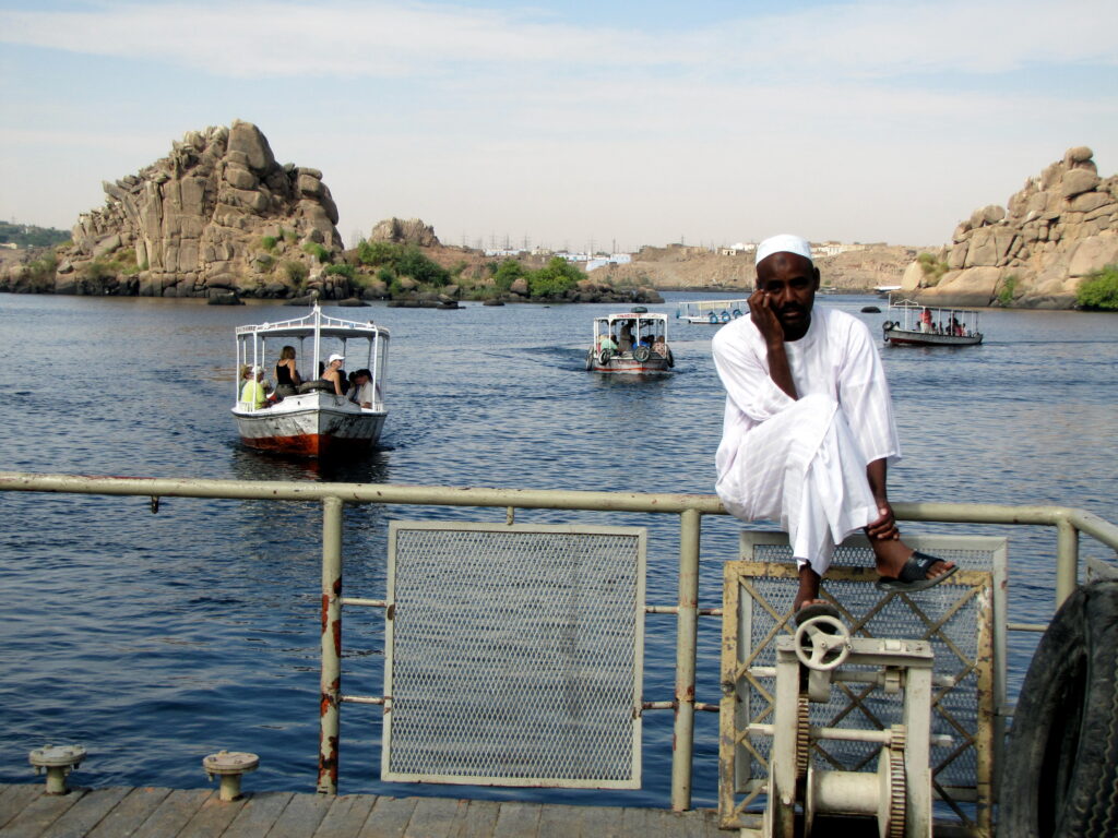 A traditional felucca sailing on the Nile River at sunset, offering a scenic experience featured in this Egypt travel guide.