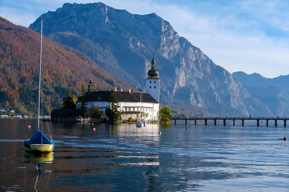 The famous wooden bridge leading to the island castle of Schloss Ort in Lake Traunsee, Gmunden, Austria.