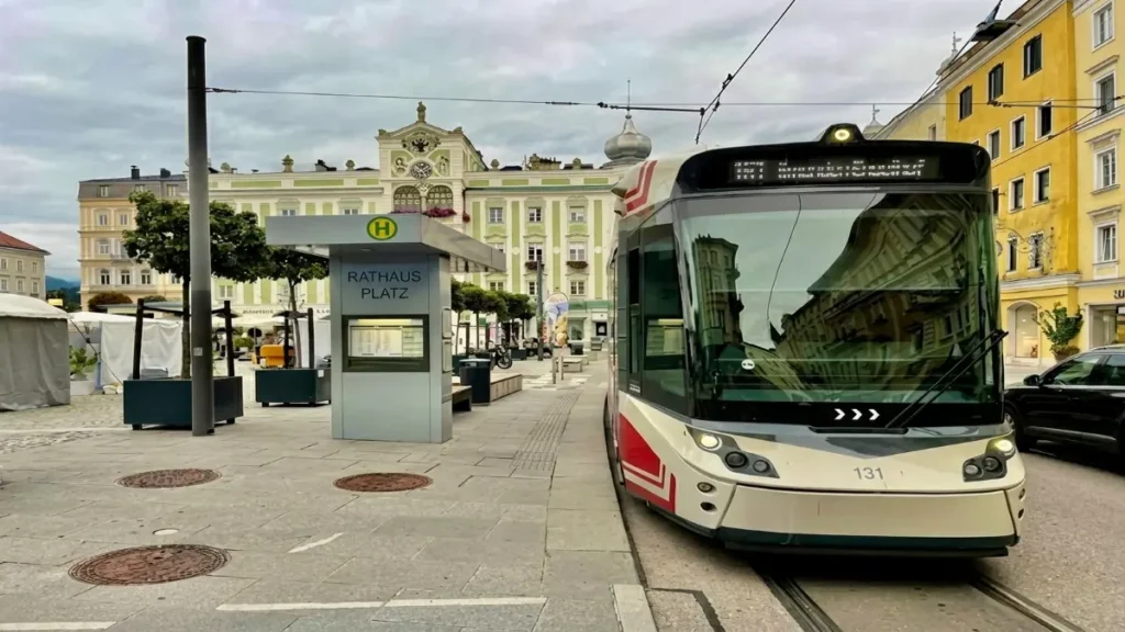 Traunseetram arriving at Rathausplatz in Gmunden, Austria with the town hall and old town buildings in the background